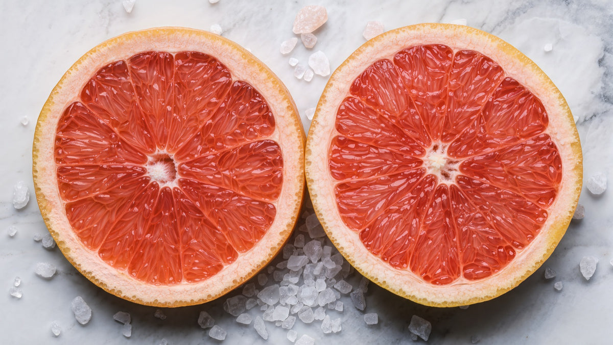 Citrus fruit and sea salt crystals on white marble surface
